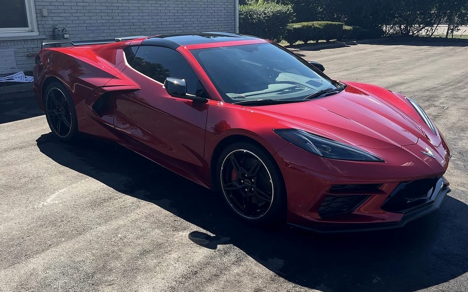 Red Chevrolet Corvette C8 with deep gloss along its flank after paint decontamination